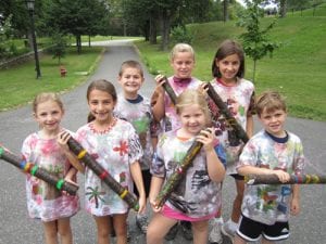 Children show T-shirts and rain sticks made in summer workshops
