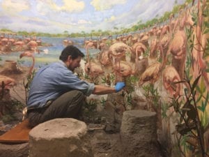 Artist Sean Murtha repairs large painting