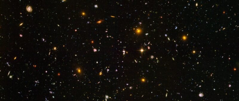 This Hubble photo shows many small, right stars and galaxies on a black background.