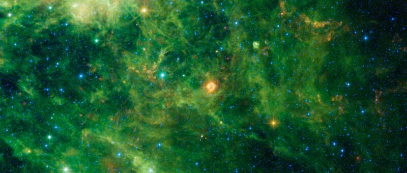 A bright green nebula surrounds many orange and green stars.