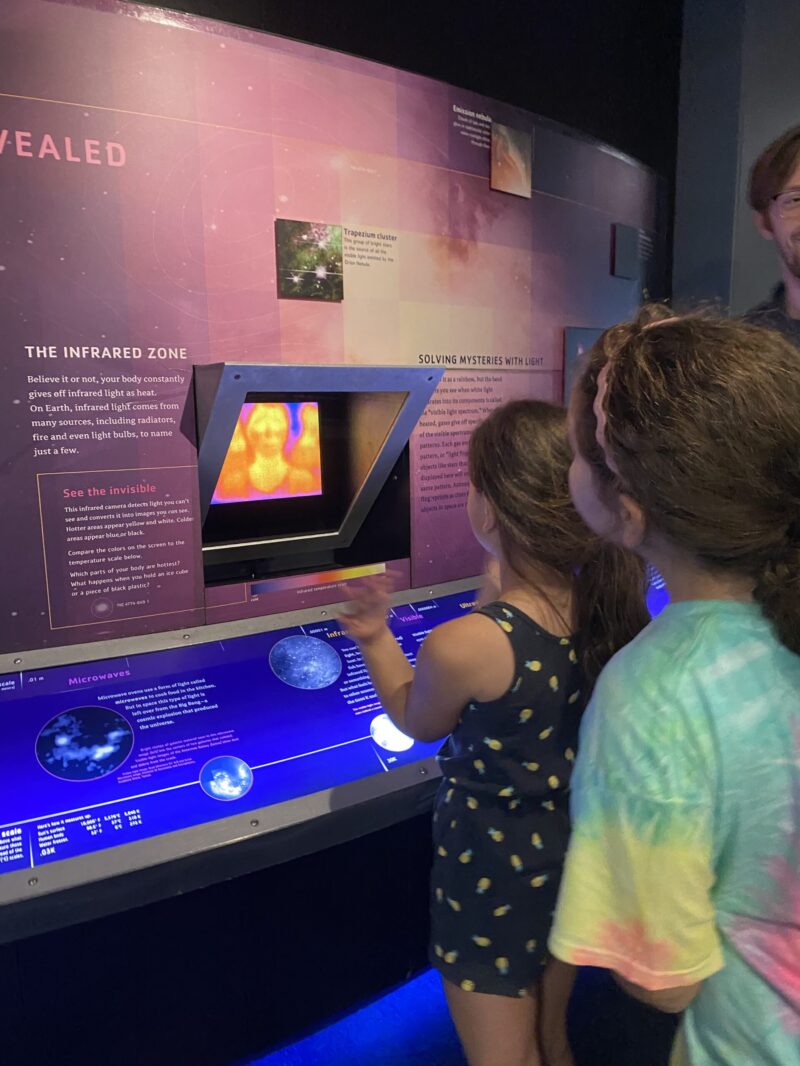 Junior Astronomers explore infrared light using one of the planetarium lobby exhibits.