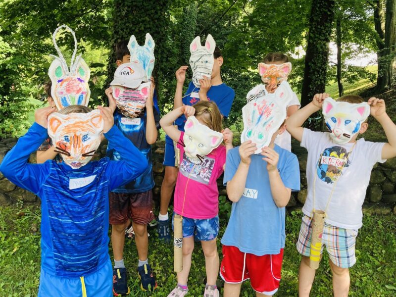 A group of Junior Explorers wearing masks they made.