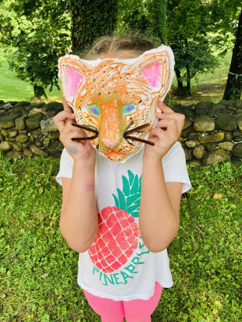 A Junior Explorer wears a cat mask.